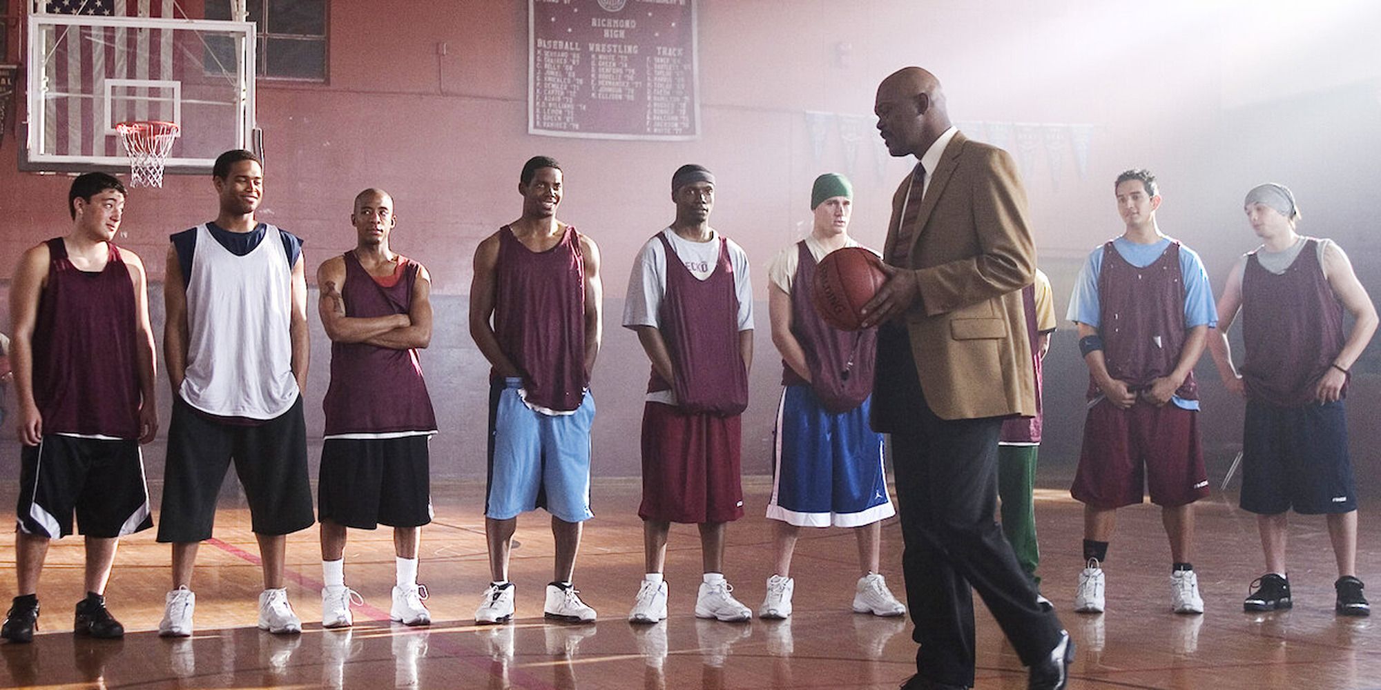 Coach Carter holding a ball, talking to his team on the court