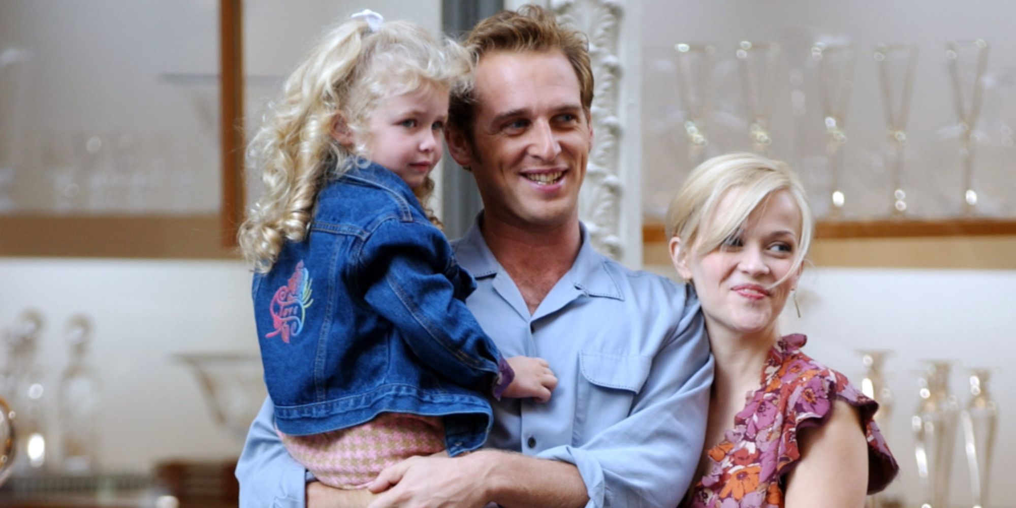 Josh Lucas and Reese Witherspoon with their daughter looking happy 