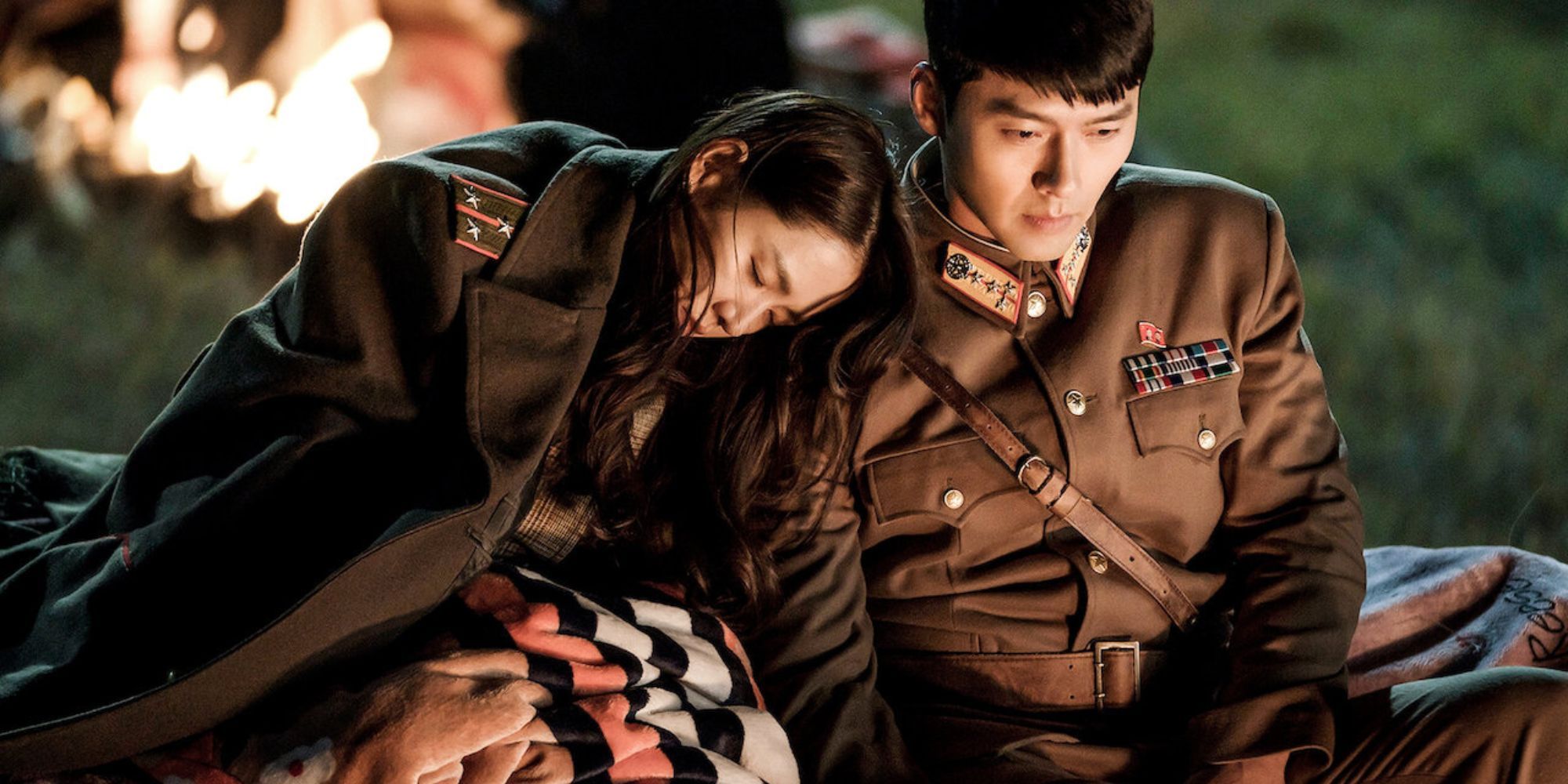 Yoon Se Ri and Ri Jeong Hyeok from Crash Landing On You sitting near a bonfire