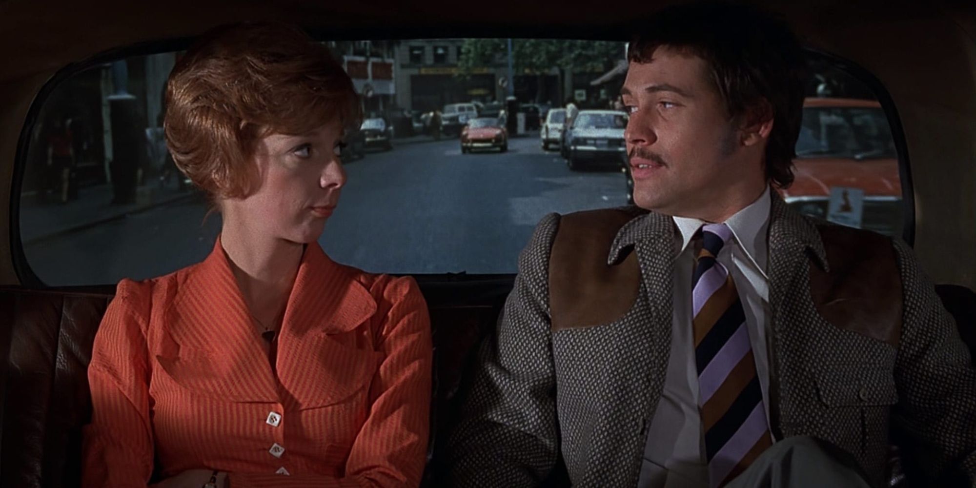 Two people sitting in the back of a car in the Alfred Hitchcock movie Frenzy (1972).