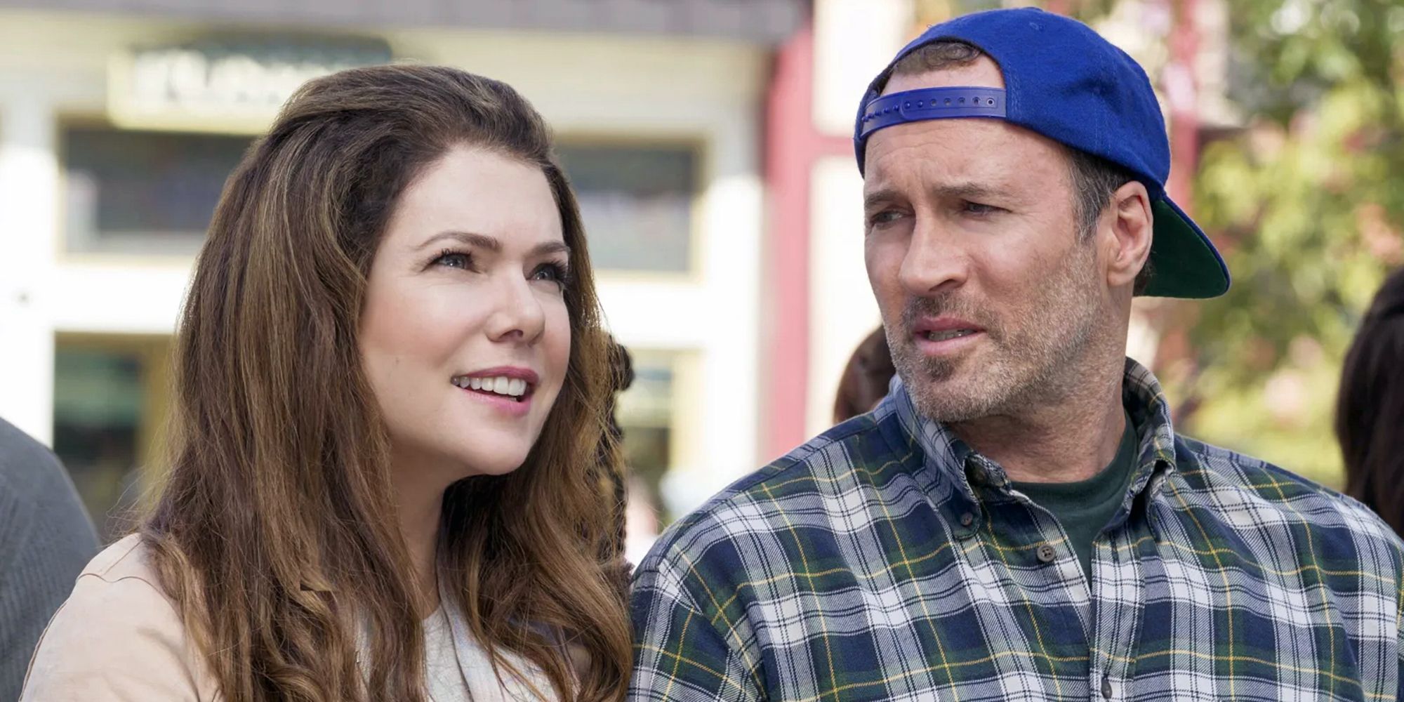 Lorelai (Lauren Graham) smiling and looking ahead while Luke (Scott Patterson) looks at her in Gilmore Girls: A Year in the Life