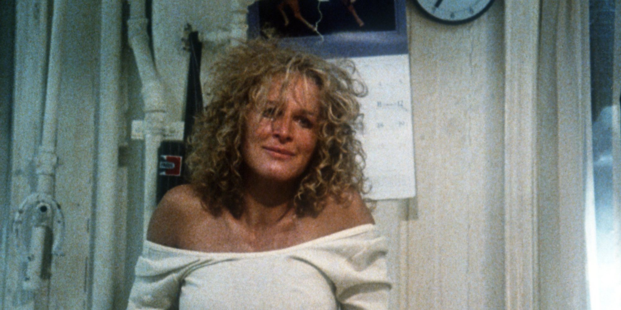 Glenn Close as Alex, in an off the shoulder white shirt, smiling in an unnerving way in Fatal Attraction