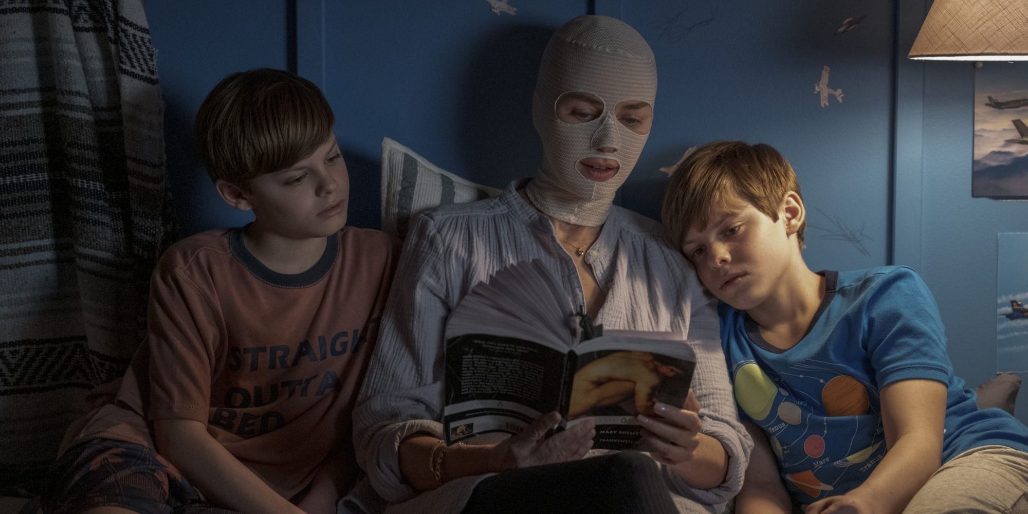 Naomi Watts' character with bandages on her face reading to her boys in bed in 'Goodnight Mommy.'