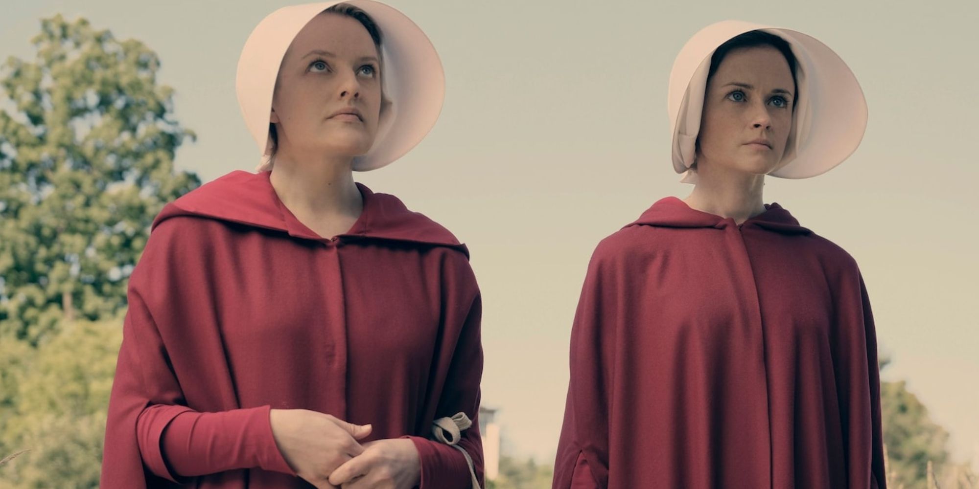 Offred and Ofglen walking together in their red robes