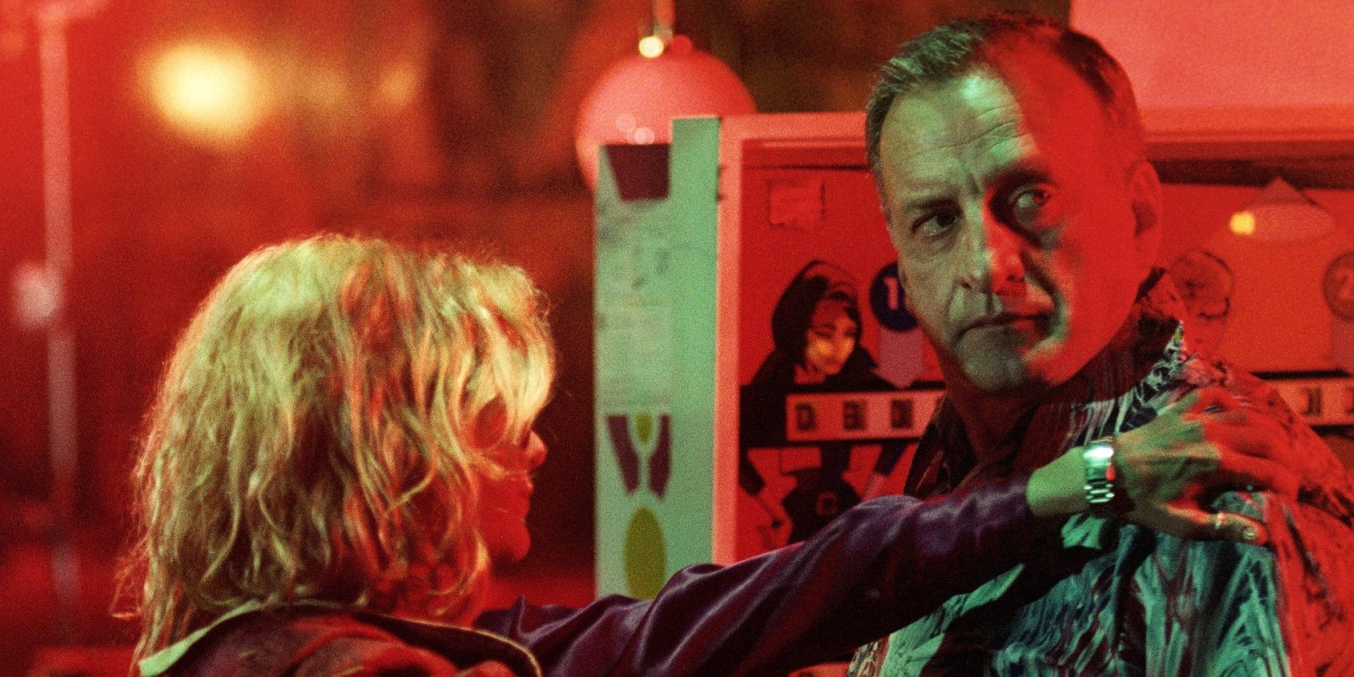 Jake VanDorn (George C. Scott) stands in a harsh red light, looking over his shoulder as a young woman places her hand on his shoulder in &lsquo;Hardcore&rsquo; (1979)