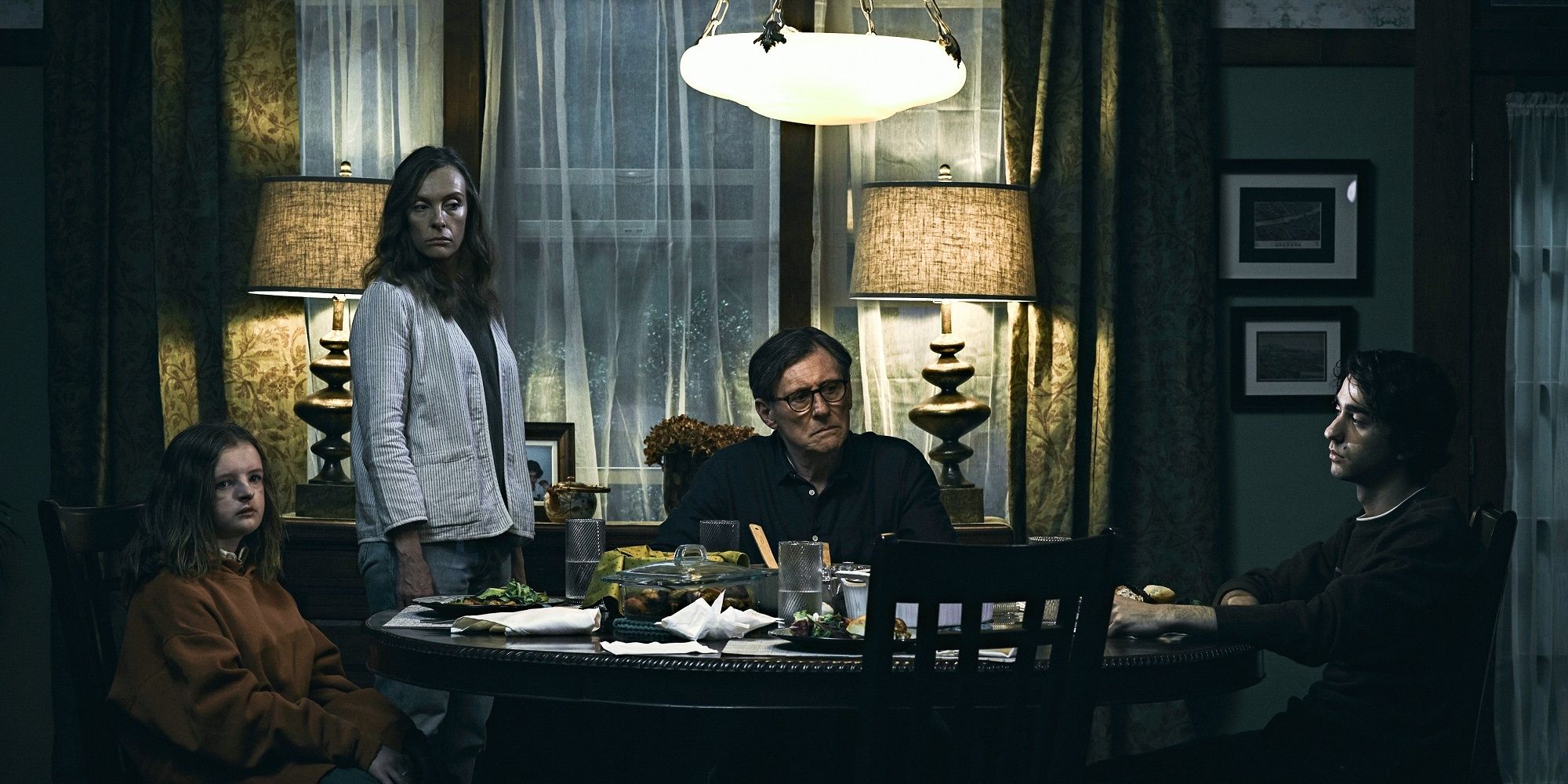 The Graham family looking sullen around the dinner table in 'Hereditary.'