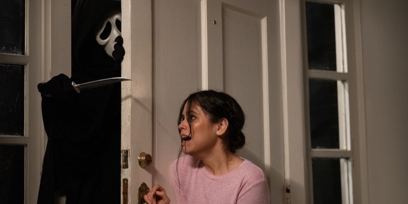 Jenna Ortega holding a door shut as Ghostface tries to break-in in Scream (2022)