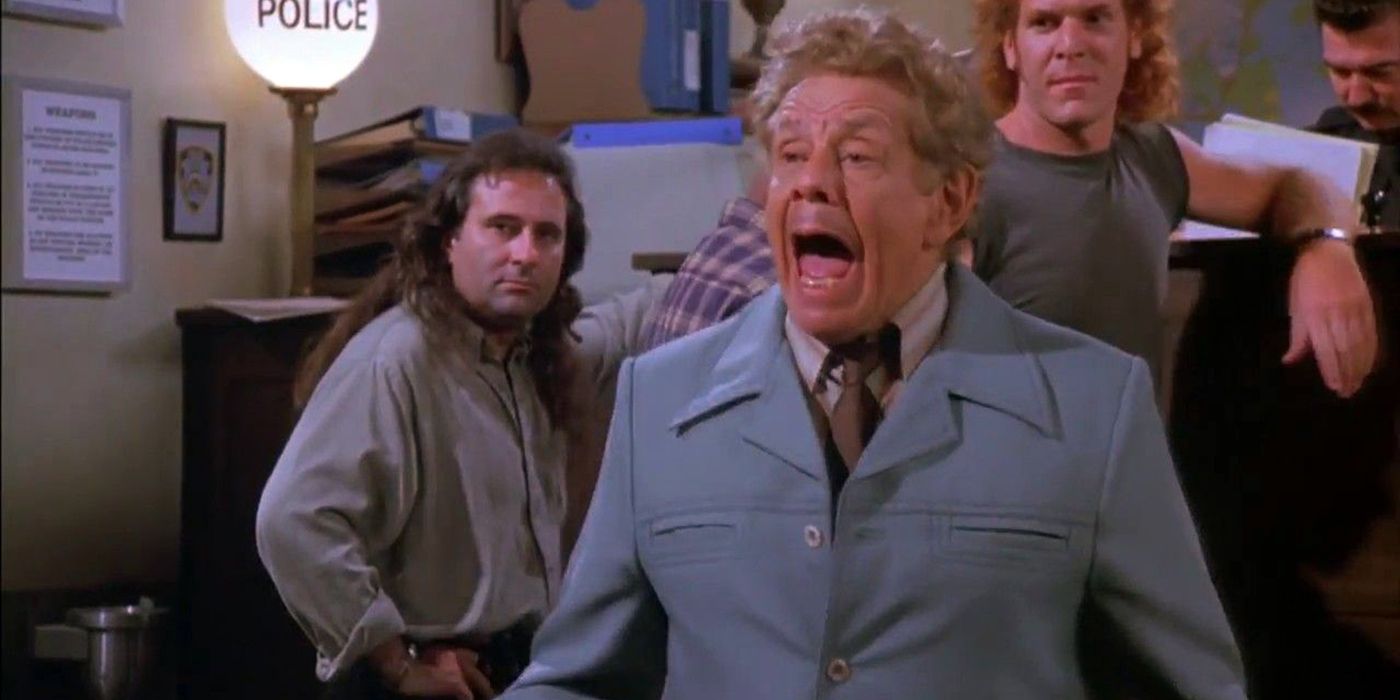 Jerry Stiller dans le rôle de Frank Constanza dans 'Seinfeld' en train de crier, des gens regardant en arrière-plan.