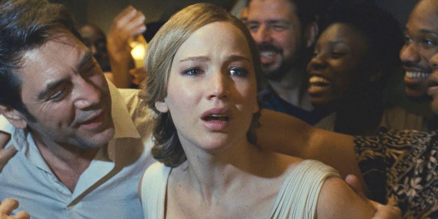 Mother, played by Jennifer Lawrence, looking terrified as a bunch of smiling people crowd around her in Mother!