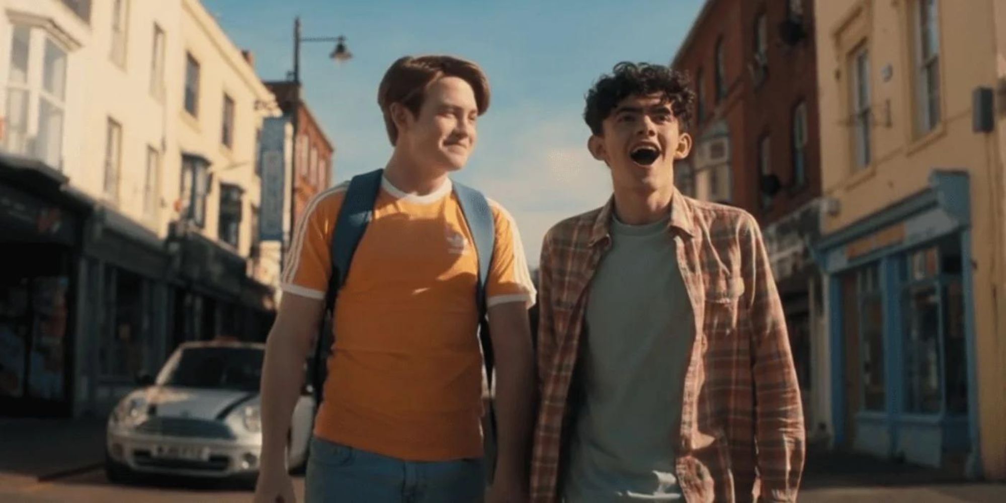 Kit Connor and Joe Locke Nick and Charlie in Heartstopper, holding hands and walking happily down the street