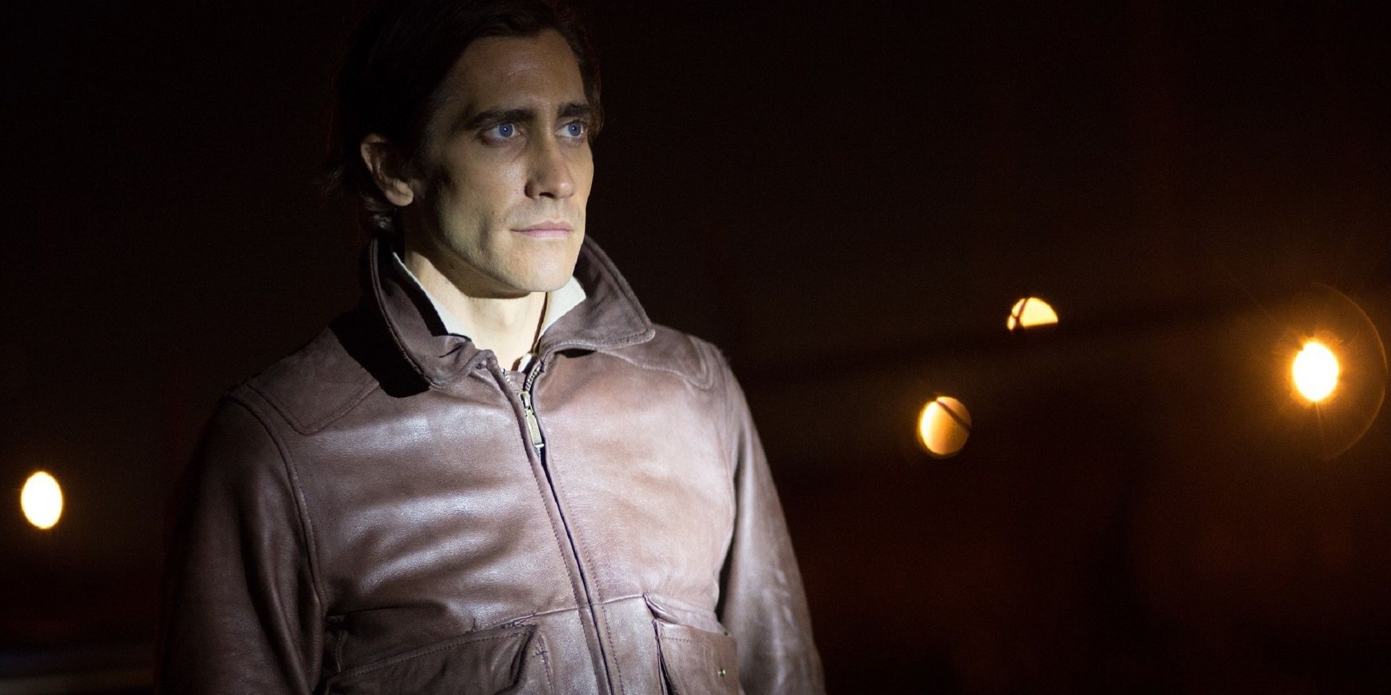 Lou Bloom under the light of a flashlight while being questioned by a cop in 'Nightcrawler.'