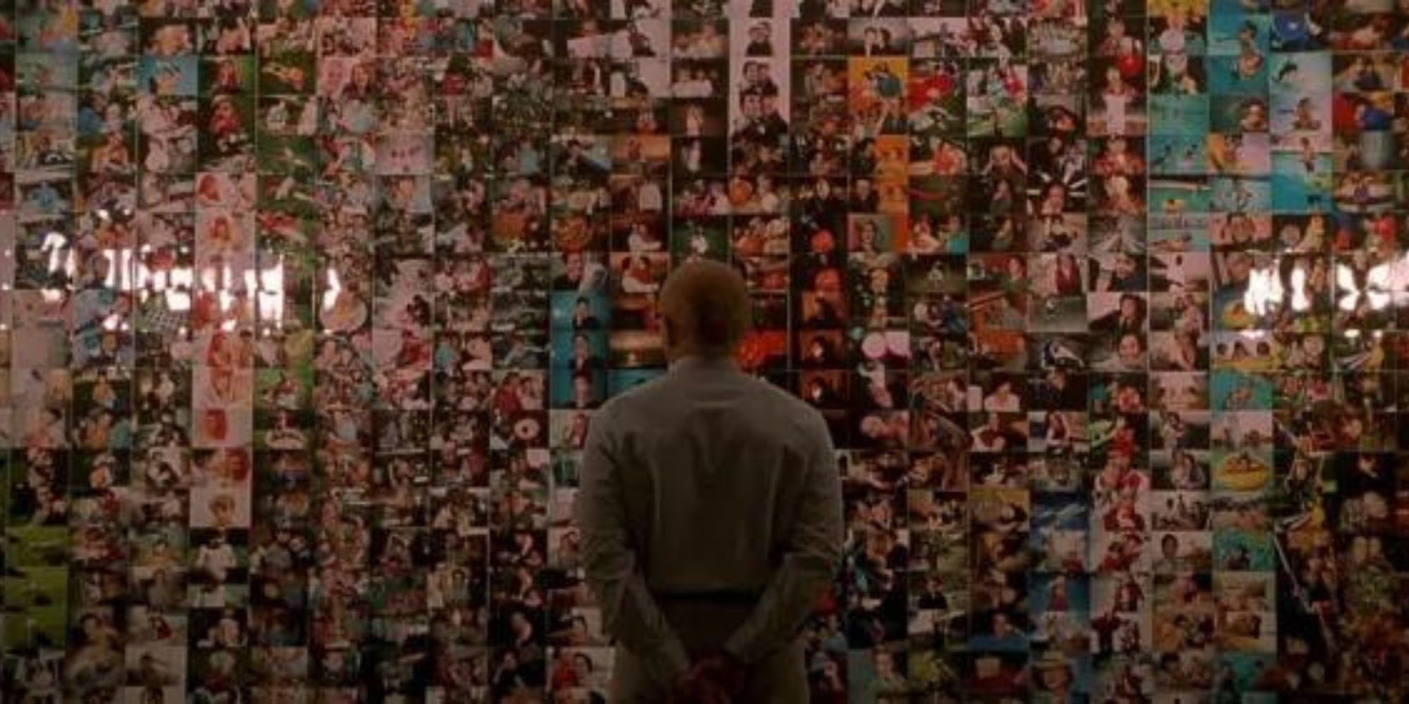 Sy looking at a wall of photos of the Yorkin family in One Hour Photo (2002)