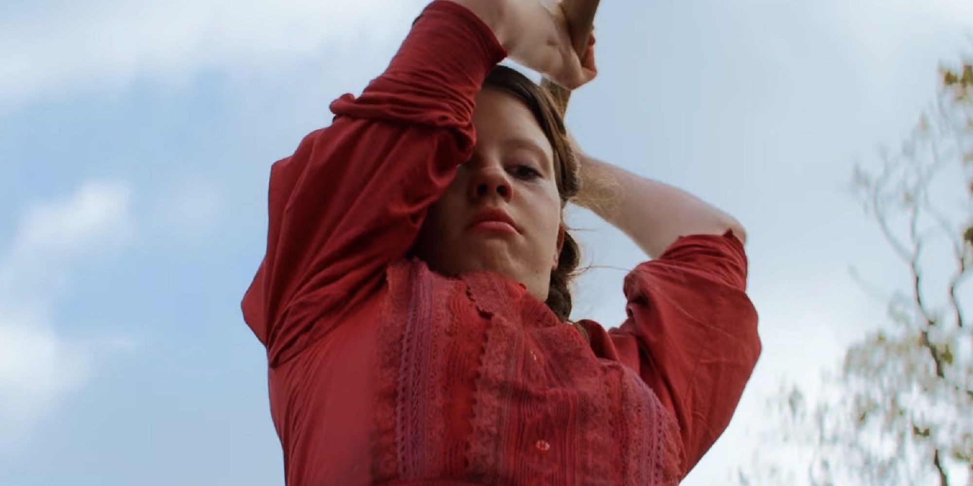 Mia Goth as Pearl swinging an axe down at the ground in 'Pearl.'