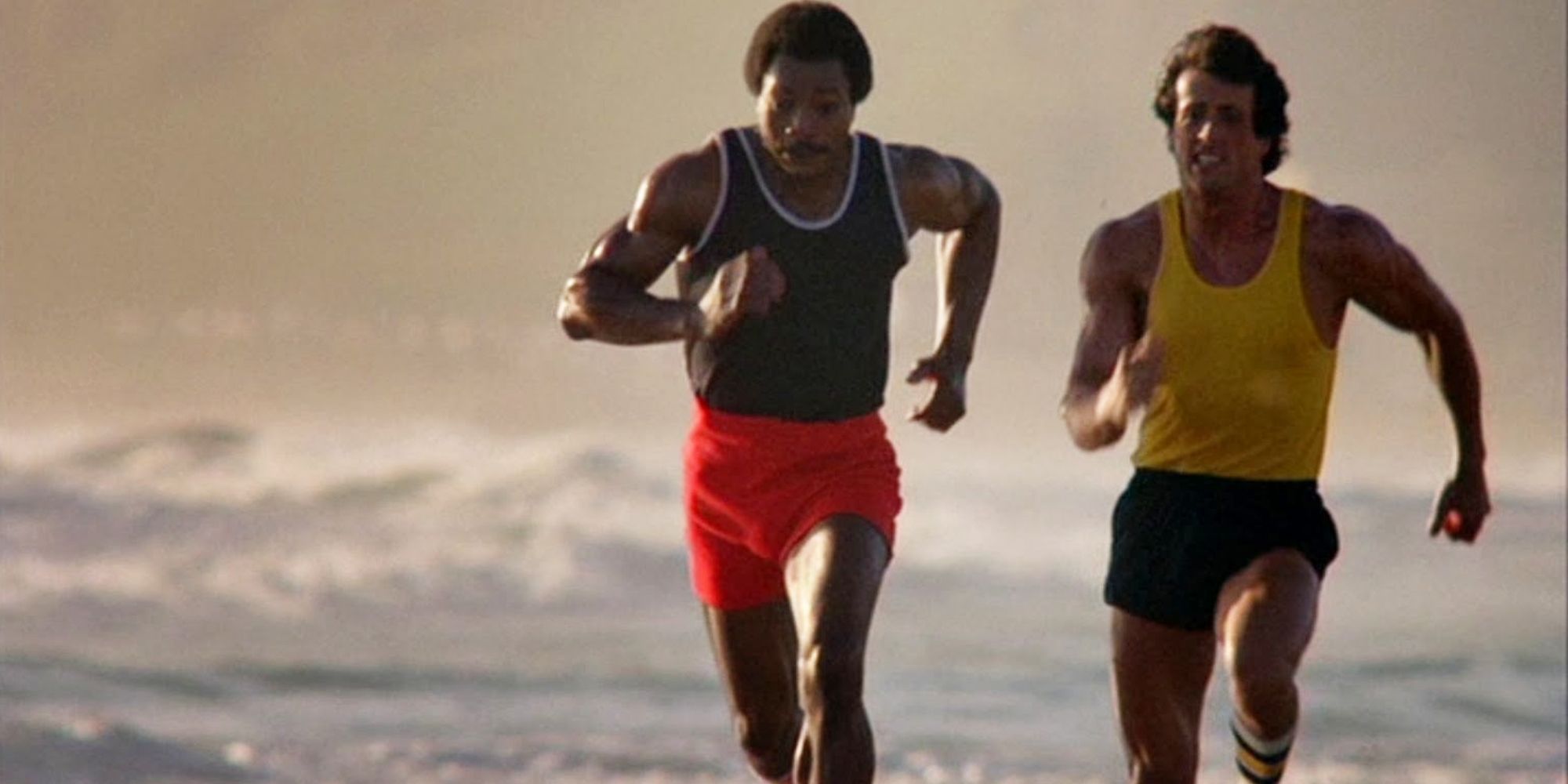 Carl Weathers and Sylvester Stallone as Apollo Creed and Rocky Balboa, running on the beach in Rocky III