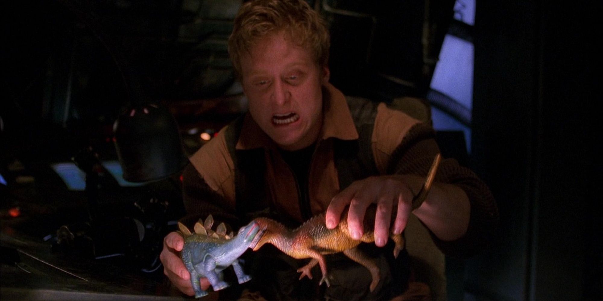 A man playing with toy dinosaurs