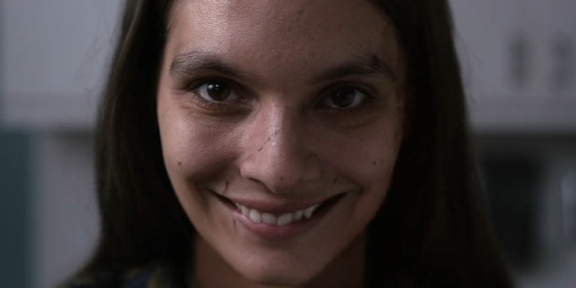 Caitlin Stasey smiles eerily for the camera in 