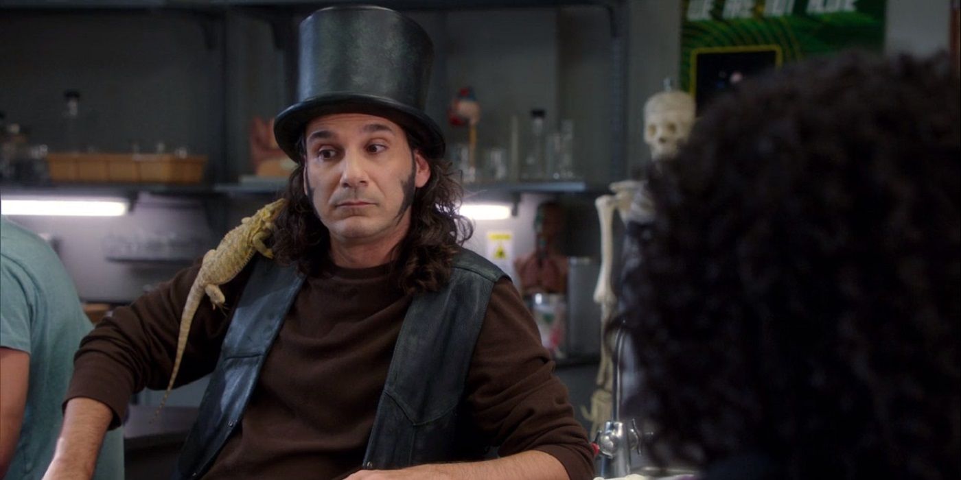 Dino Stamatopoulos as Alex "Star-Burns" Osbourne on Community wearing a top hat with a lizard on his shoulders.
