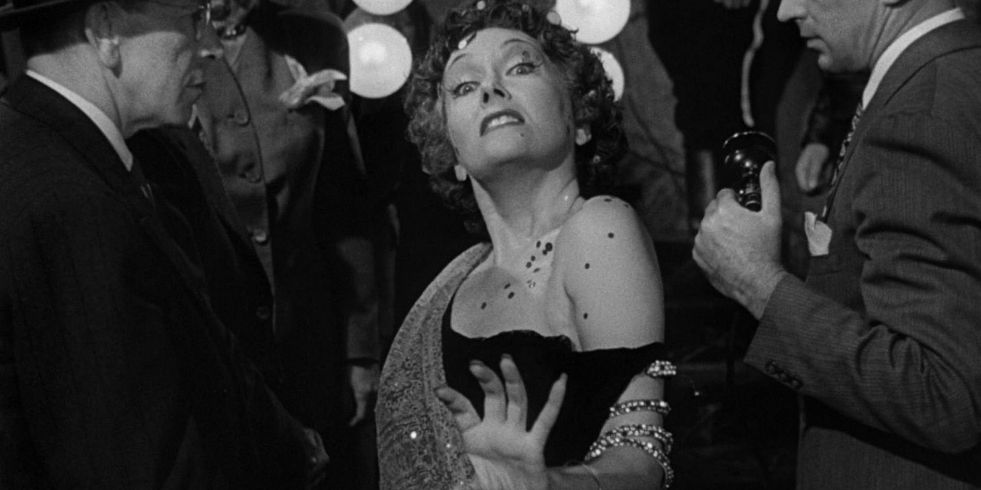 Norma Desmond glides through a pack of photographers announcing she is ready for her close-up.