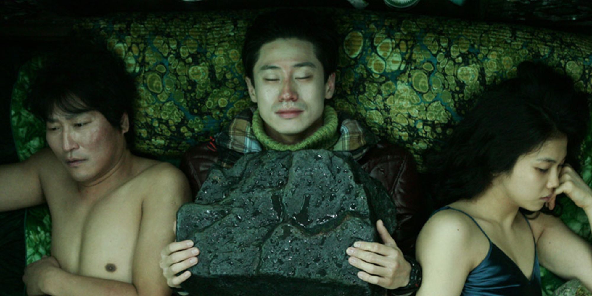 Three characters lying on a bed in Thirst