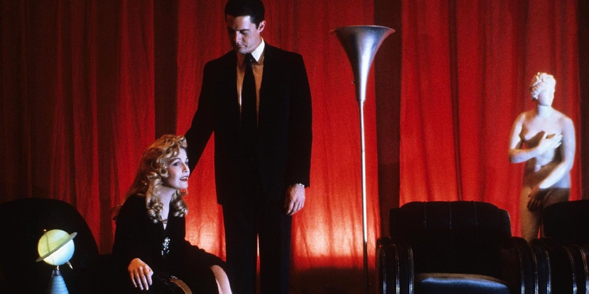 Kyle MacLachlan and Sheryl Lee as Dale Cooper and Laura Palmer in a room with red curtains in Twin Peaks: Fire Walk With Me