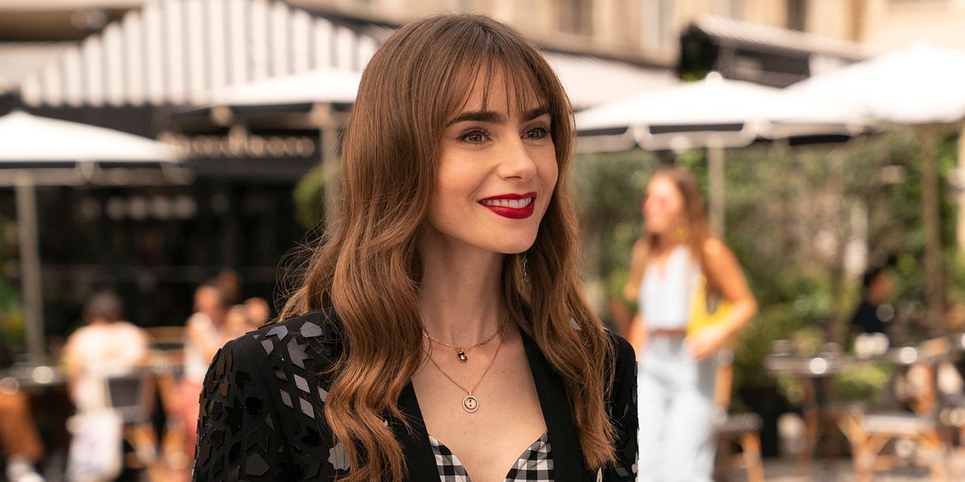 Emily smiling widely while standing on the street in Emily in Paris.