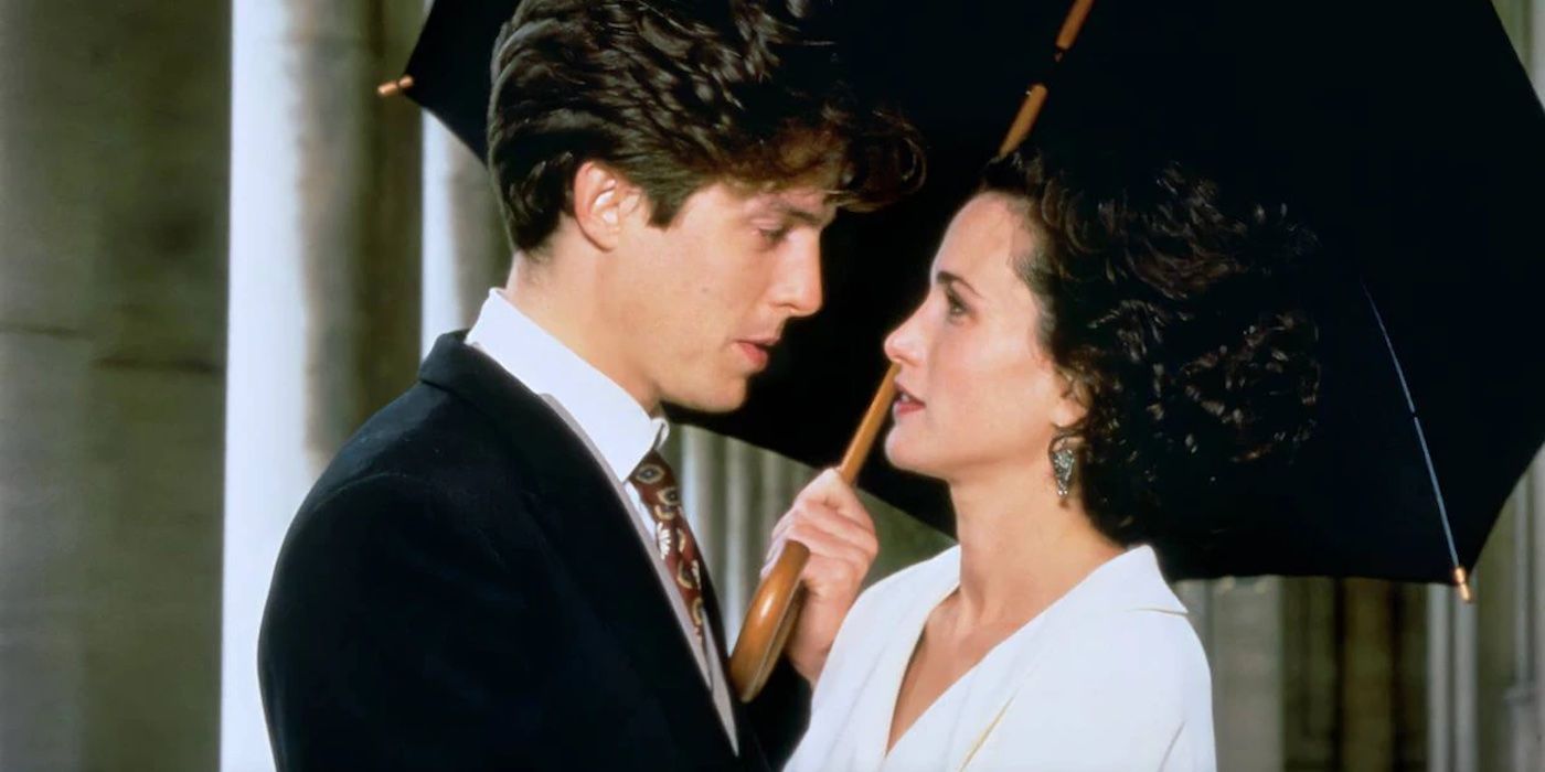 Charles, played by Hugh Grant, holding an umbrella over Carrie, played by Andie MacDowell, as they look into each other's eyes in Four Weddings and a Funeral