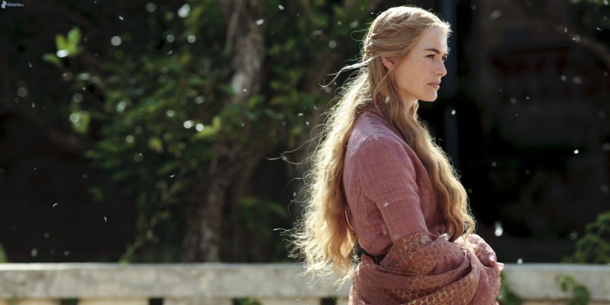 A blonde woman is standing by the balcony