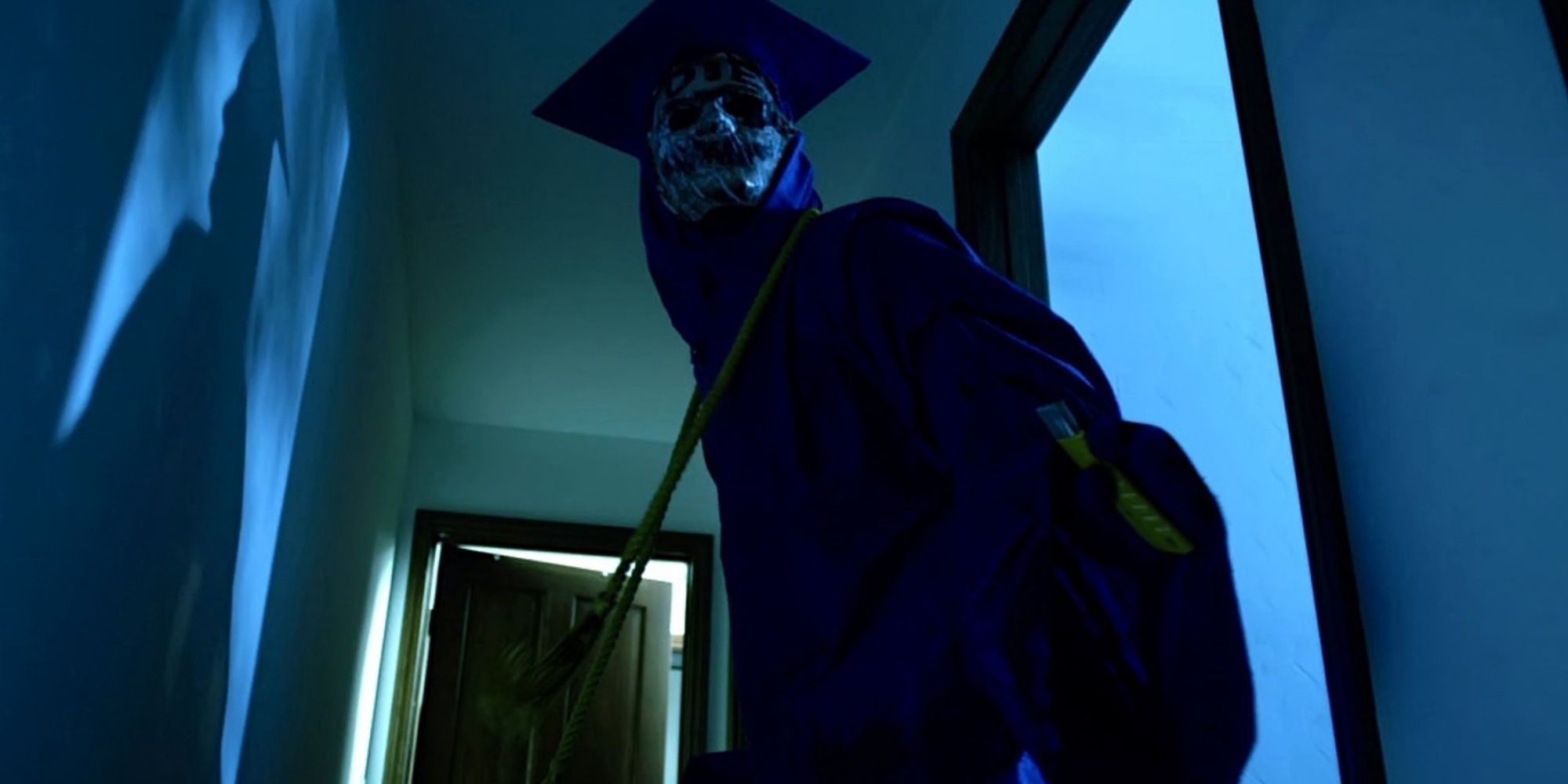 The graduate killer looms menacingly in a corridor