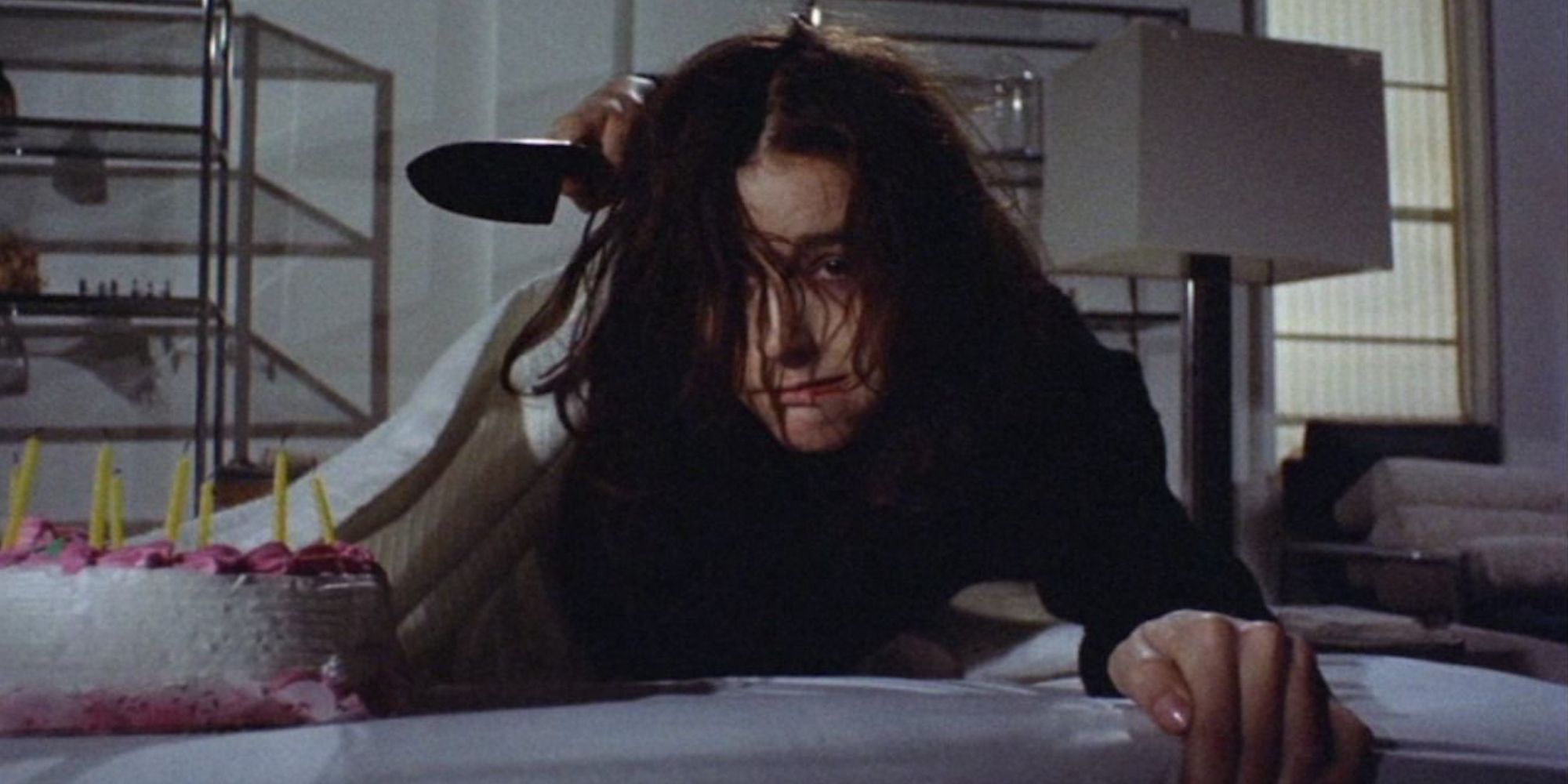 Margot Kidder holding a knife looking disheveled in Sisters