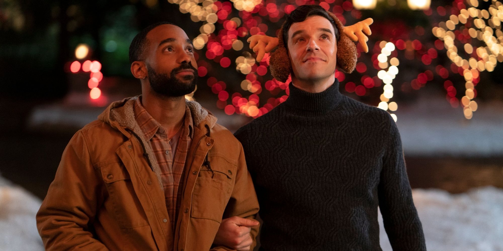 Nick and Peter standing together looking at Christmas ornaments in Single All The Way.