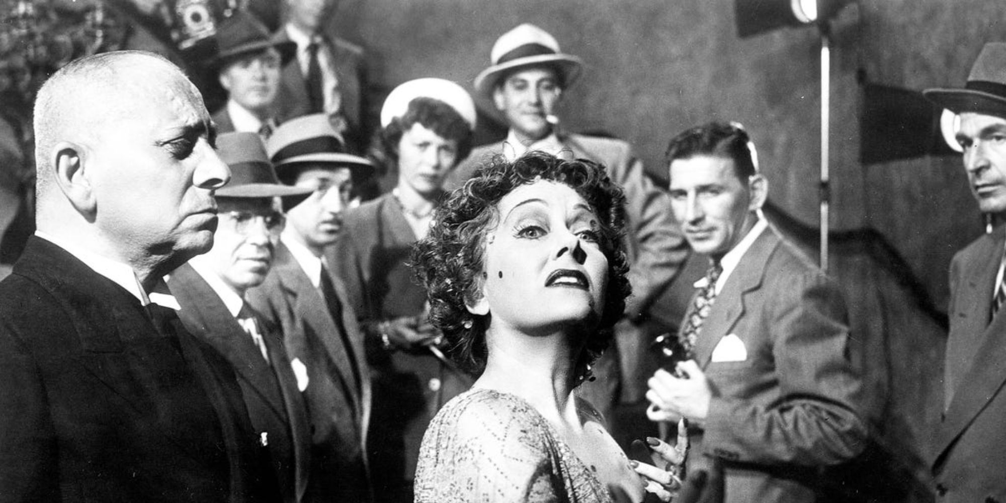 Gloria Swanson como Norma Desmond em Sunset Boulevard é cercada por espectadores