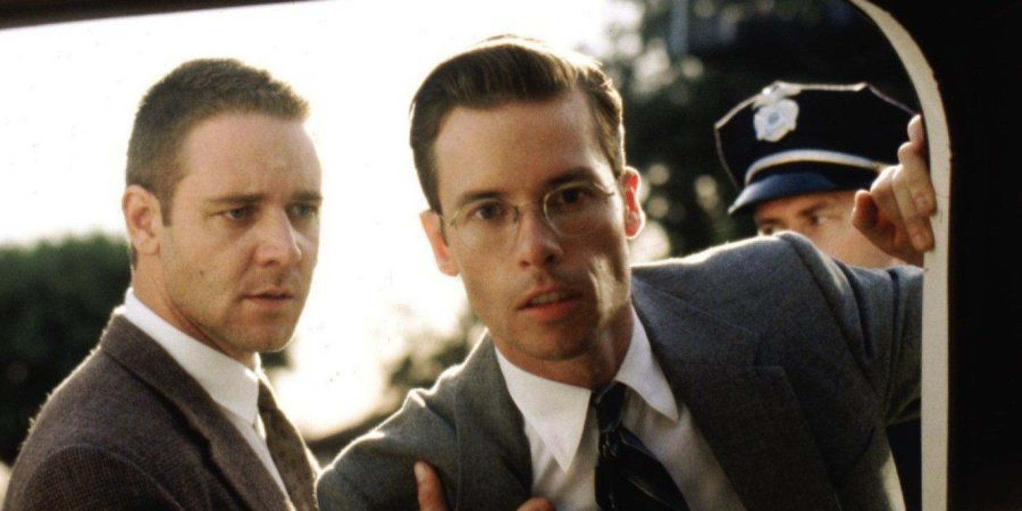 Bud standing next to Exley who is looking into a car in L.A. Confidential