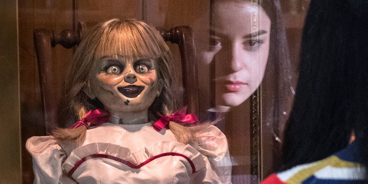 Katie Sarife as Daniela looking at a possessed doll in &lsquo;Annabelle Comes Home&rsquo;