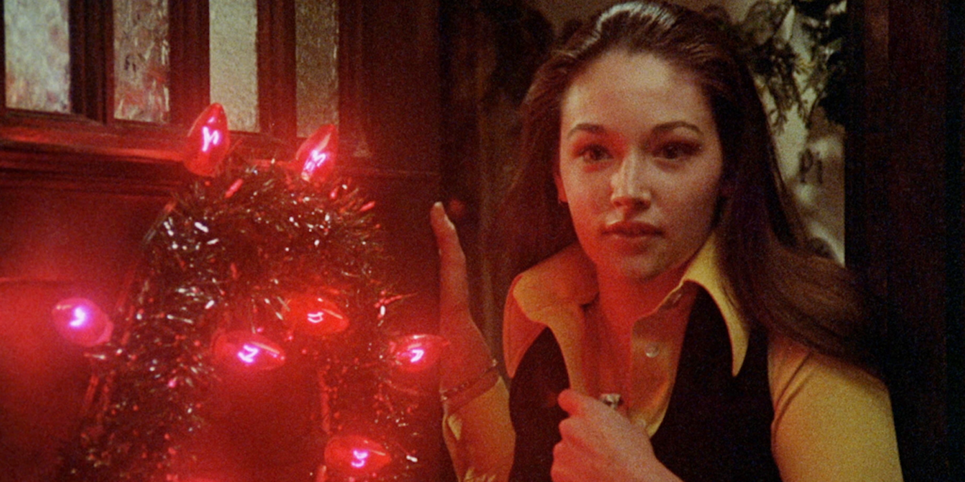 Olivia Hussey standing over a lit Christmas tree in Black Christmas
