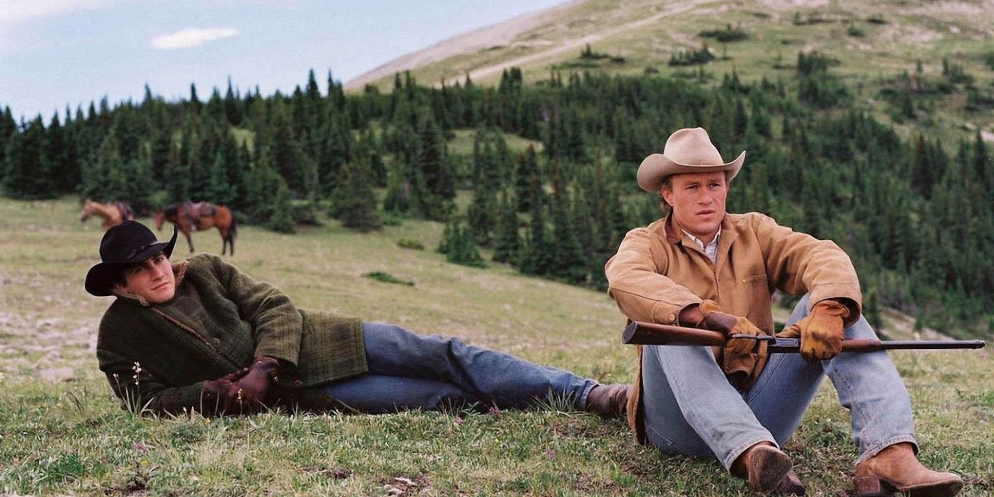 Two cowboys sitting on the grass together