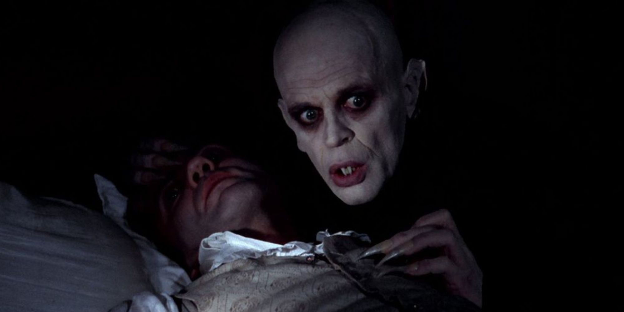 Klaus Kinski planant au-dessus d'une victime dans Nosferatu le vampire.