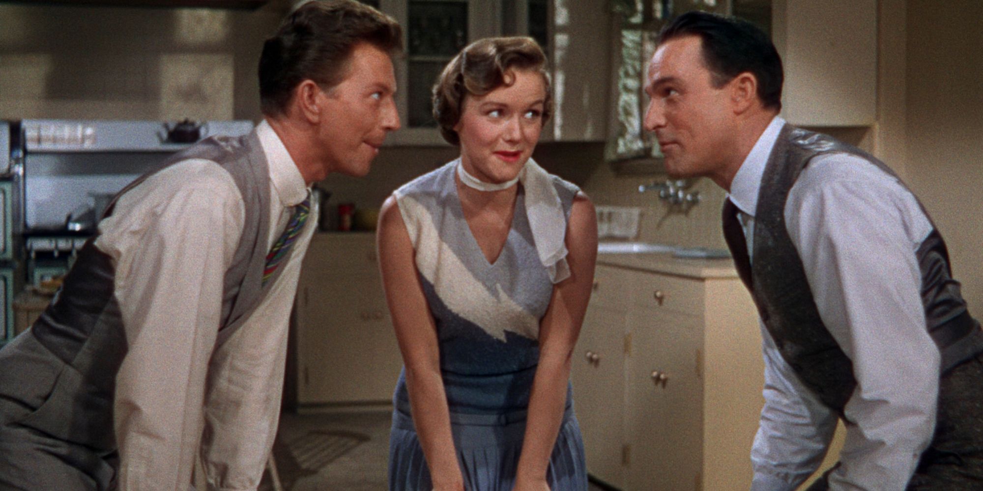 Donald O'Connor as Cosmo Brown, Debbie Reynolds as Kathy Selden, and Gene Kelly as Don Lockwood huddling in Singin' in the Rain 