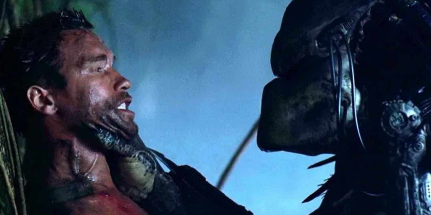 The Predator holds Arnold Schwarzenegger as Dutch by the throat in Predator (1987).