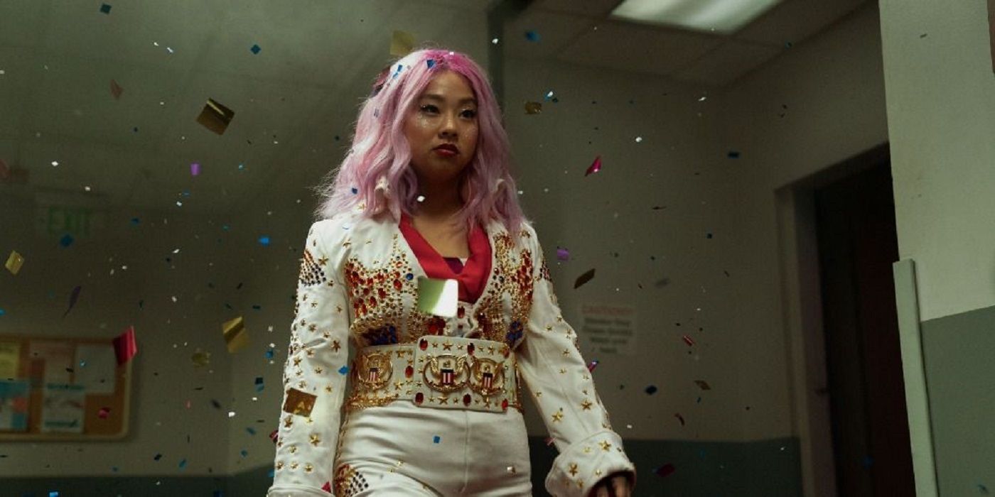 Stephanie Hsu as Jobu Tupaki, walking down a hall while glitter falls from the ceiling in Everything Everywhere All at Once