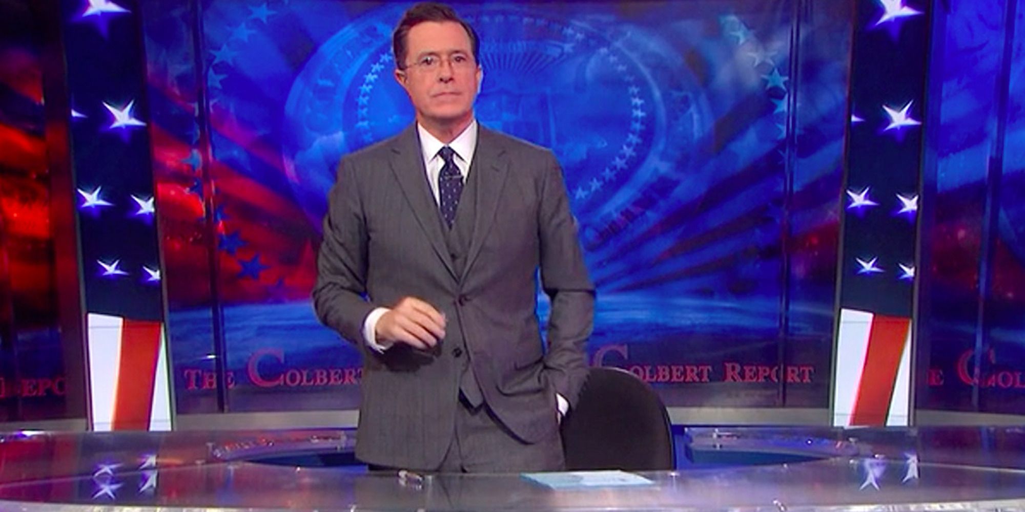Stephen Colbert in front of a background of American symbols reading &ldquo;Colbert Report&rdquo;