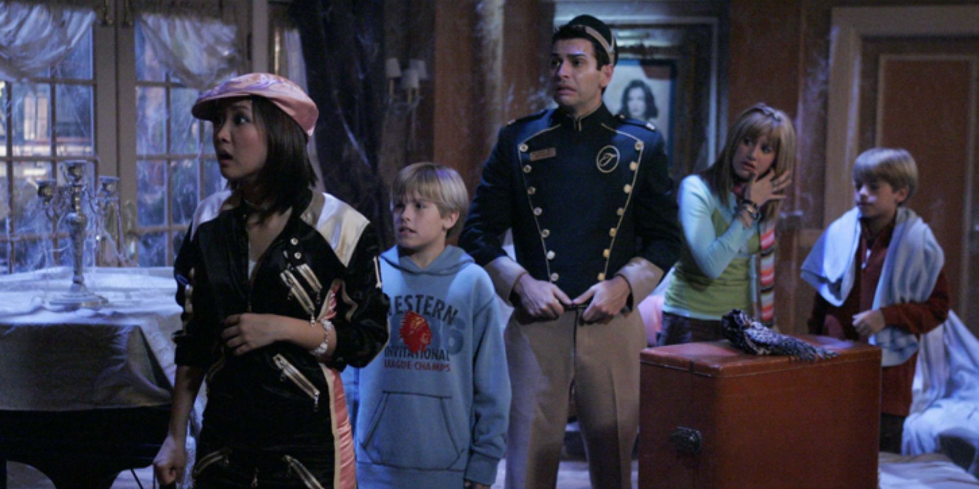 The cast look scared as they walk through a dark and dusty room in The Suite Life of Zack &amp; Cody.