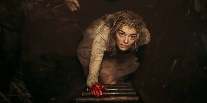 Dirty and bloody, Grace (Samara Weaving) climbs a ladder in Ready or Not.