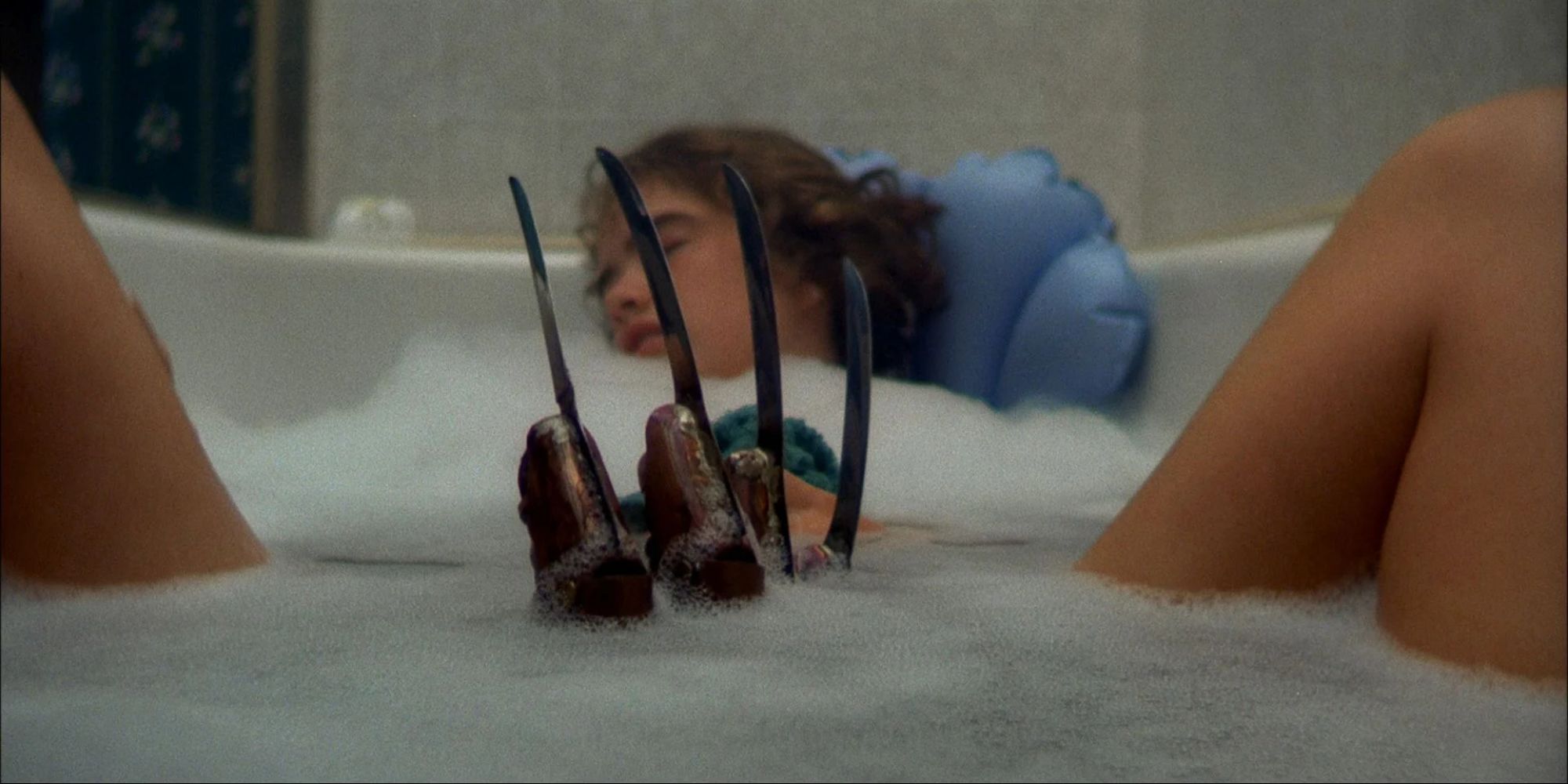 Heather Langenkamp taking a bath as a claw rises between her legs in A Nightmare on Elm Street