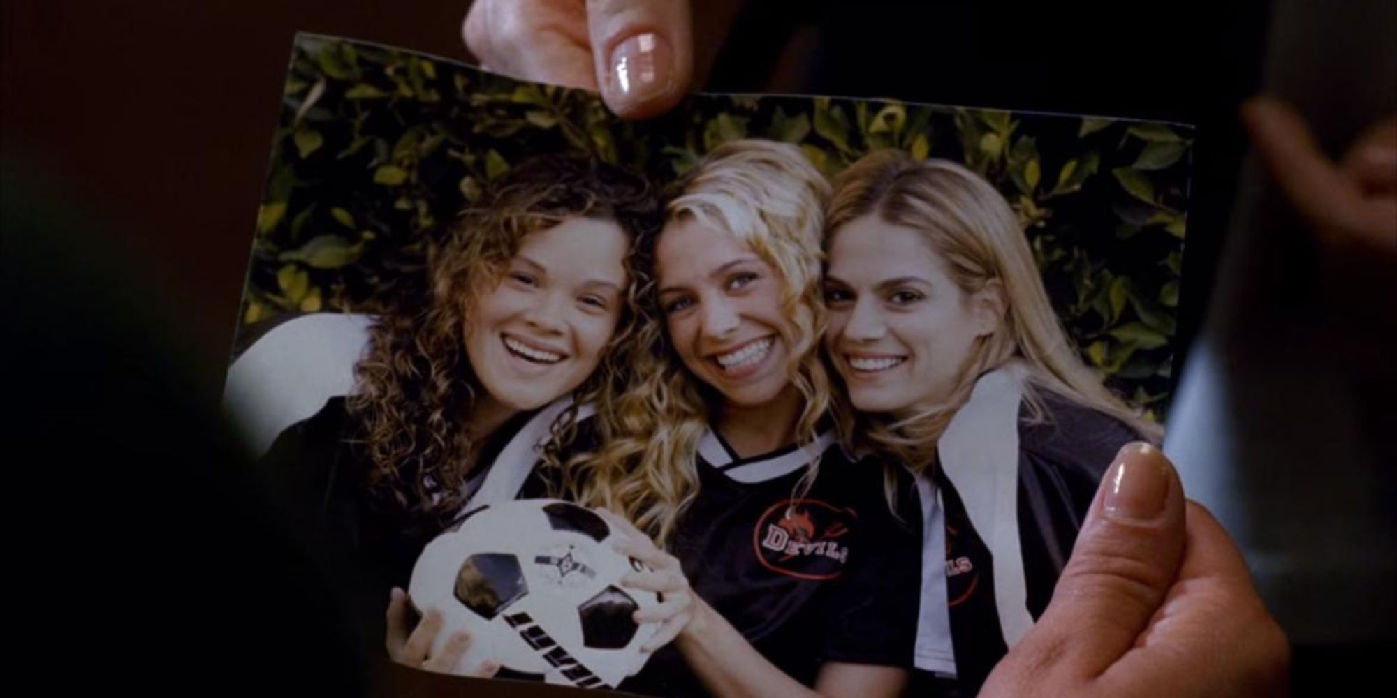 a picture of three girls in soccer uniform