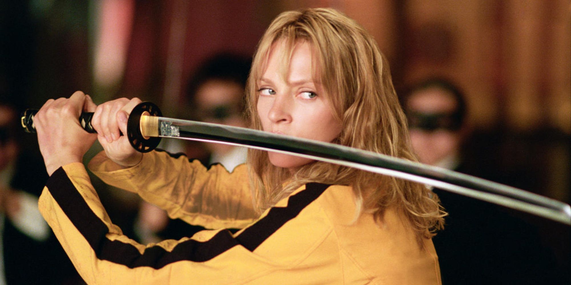 Uma Thurman sebagai Mempelai Wanita berjas kuning dengan pedang katananya di Kill Bill Volume 1