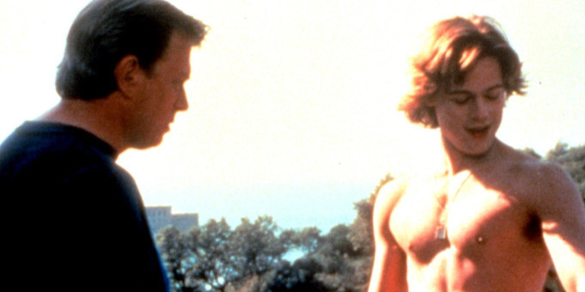 a man is shirtless standing in the sun with another man