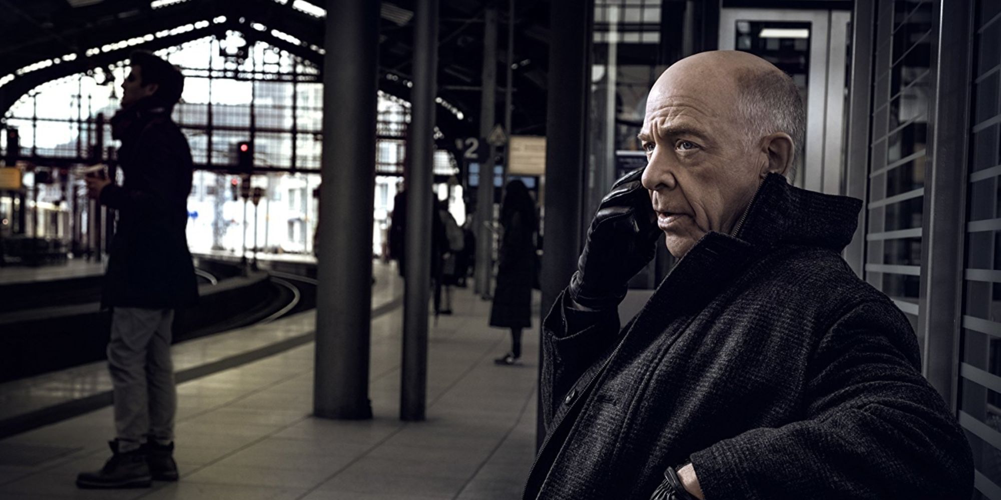 un homme assis à la gare en train de parler au téléphone