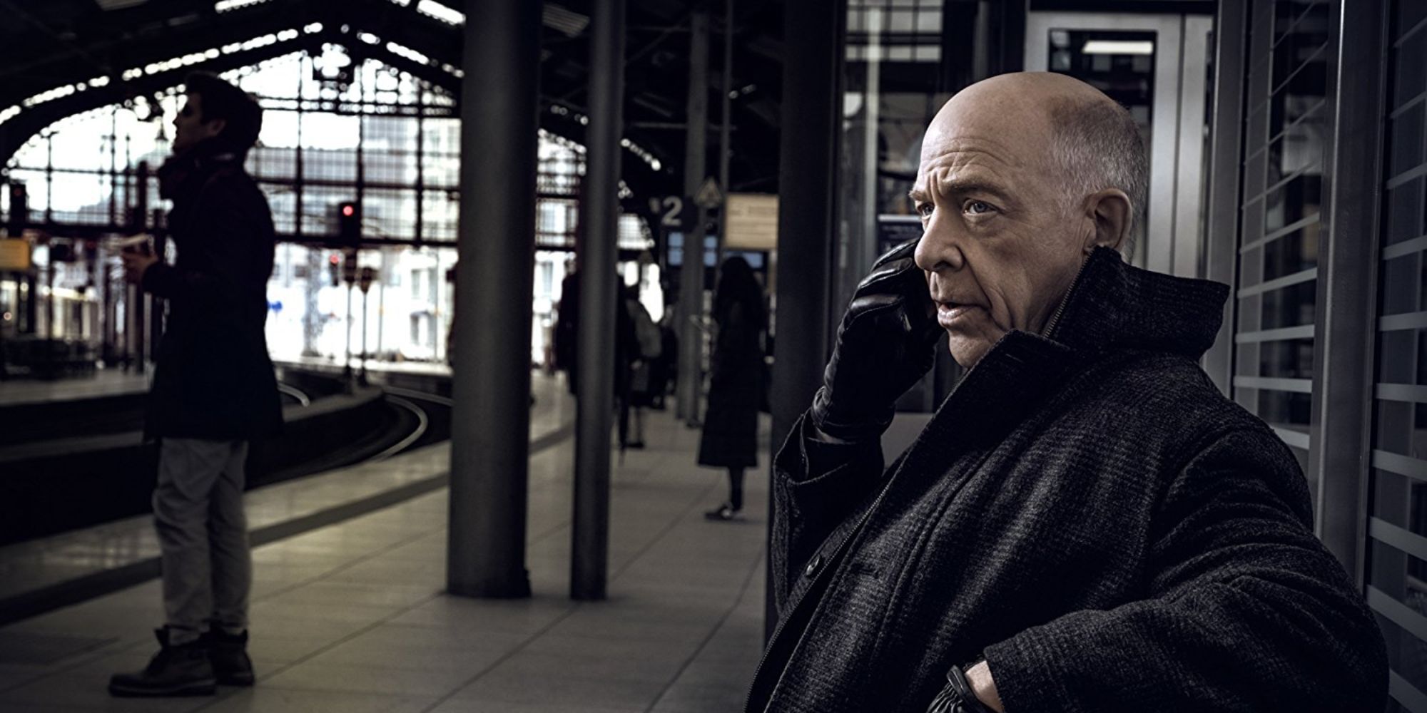 a man sitting at the train station talking on the phone