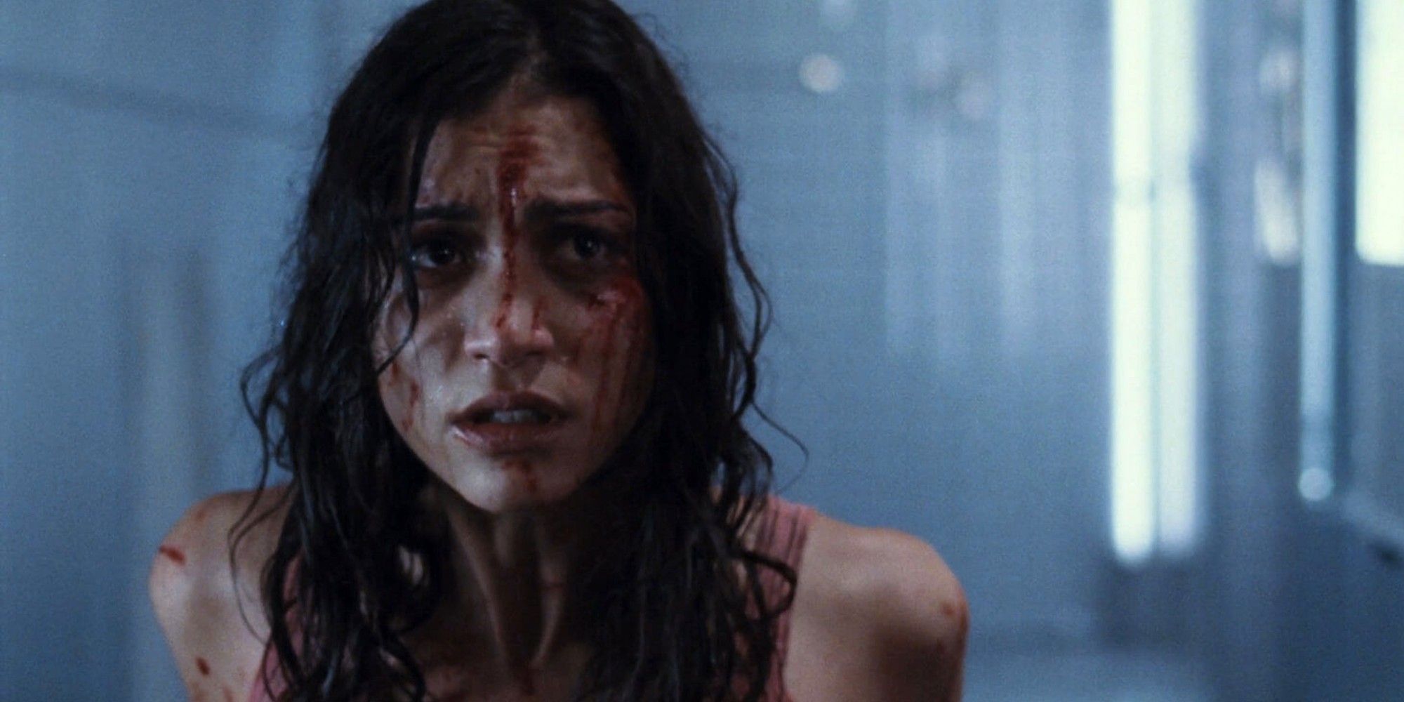 Morjana Alaoui with a bloodied face crying in 'Martyrs'