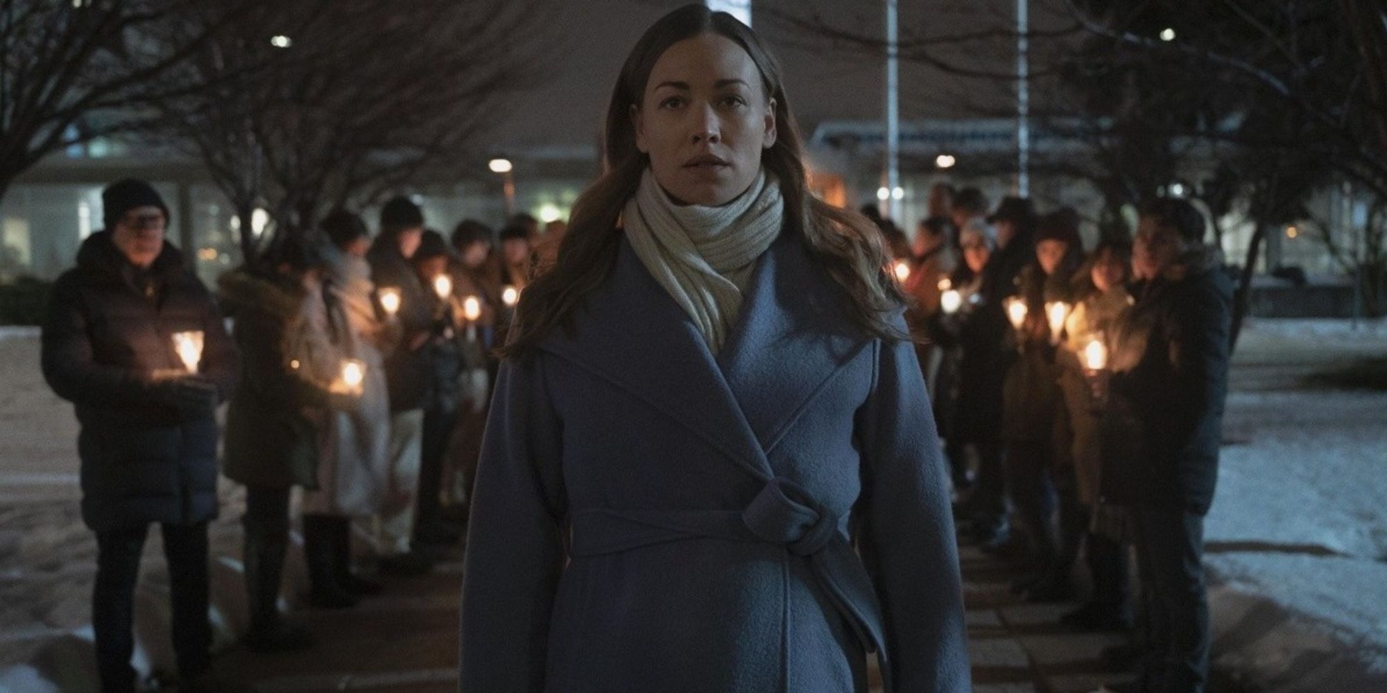 Serena walks through a candle-lit prayer group